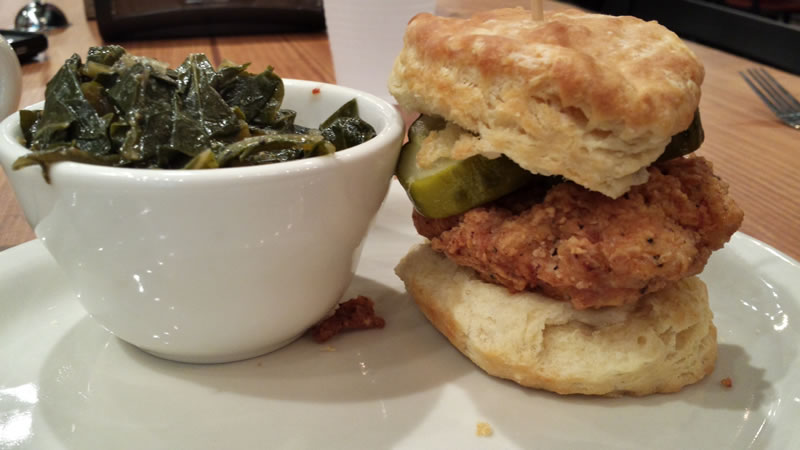 Chicken biscuit sandwich and a side of collard greens.