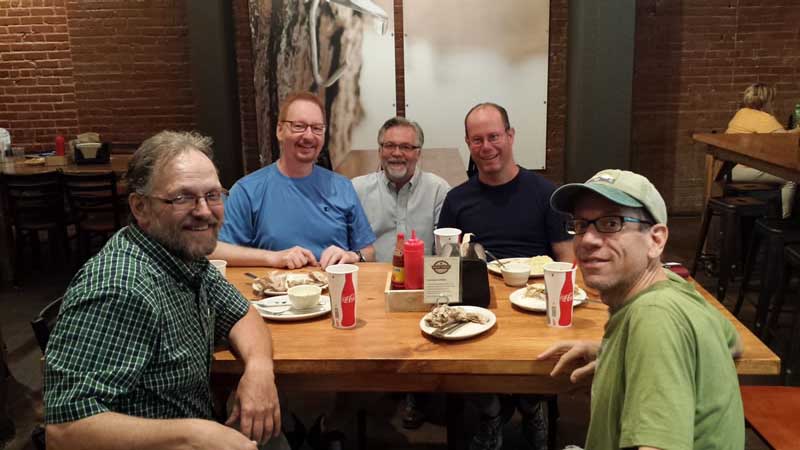 Founder, Scott Moore, sits between violinists Carl Johnston and Cal Lewis. Principal bassoonist and principal horn, Eric Anderson and Gordon James sit on the opposite side